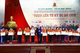 Trao tặng Bằng khen cho các học sinh là con, cháu thương binh, nạn nhân chất độc da cam/dioxin tiêu biểu, vượt khó vươn lên, giành kết quả xuất sắc trong học tập và rèn luyện, ngày 27/8/2017. (Ảnh: An Đăng/TTXVN) 