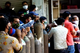 Người dân xếp hàng chờ bơm đầy bình ôxy để cung cấp cho bệnh nhân COVID-19 tại New Delhi, Ấn Độ. (Ảnh: THX/ TTXVN) 