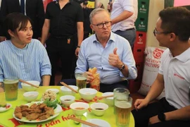 Thủ tướng Australia Anthony Albanese dành lời khen với bánh mỳ truyền thống của Việt Nam. (Ảnh: Lâm Khánh/TTXVN)