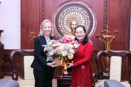 Bà Melissa Brown (trái), Phó Trợ lý Ngoại trưởng Hoa Kỳ, phụ trách khu vực Đông Nam Á tặng hoa cho bà Nguyễn Thị Lệ (phải), Phó Bí thư Thành ủy, Chủ tịch Hội đồng Nhân dân Thành phố Hồ Chí Minh. (Ảnh: Xuân Khu/TTXVN)