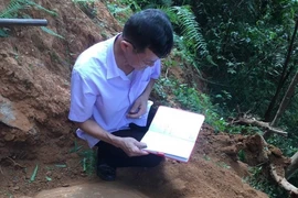 Cán bộ Bảo tàng tỉnh Yên Bái nghiên cứu tổng hợp về những khối đá khắc cổ mới được phát hiện tại thôn Háng Chua Say, xã Chế Cu Nha, huyện Mù Cang Chải. (Ảnh: TTXVN phát) 