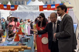 Thị trưởng thành phố Lyon Grégory Doucet và Đại sứ Việt Nam tại Pháp Đinh Toàn Thắng tham quan gian hàng Việt Nam tại Ngày hội Lãnh sự. (Ảnh: Thu Hà/PV TTXVN tại Pháp)