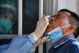 Nhân viên y tế lấy mẫu dịch xét nghiệm COVID-19 cho người dân tại Vũ Hán, tỉnh Hồ Bắc, Trung Quốc, ngày 3/9/2020. (Nguồn: AFP/TTXVN) 