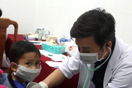 Bác sỹ khám bệnh cho trẻ nhỏ tại xã Trà Leng. (Ảnh: Trịnh Bang Nhiệm/TTXVN) 