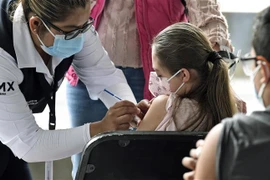 Nhân viên y tế tiêm vaccine phòng COVID-19 cho trẻ em tại Mexico City, Mexico, ngày 25/10/2021. (Ảnh: AFP/TTXVN) 