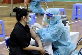 Nhân viên y tế tiêm vaccine cho người dân tại Nhà thi đấu Lãnh Binh Thăng (Quận 11, Thành phố Hồ Chí Minh). (Ảnh: Hồng Giang/TTXVN) 