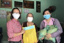 Đại diện Hội Liên hiệp Phụ nữ quận 3 trao quà cho các hộ nghèo đồng bào dân tộc Khmer. (Ảnh: Thanh Vũ/TTXVN) 