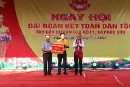 Trưởng Ban Tổ chức Trung ương Lê Minh Hưng tặng quà cho bản Cao Vều 1, xã Phúc Sơn, huyện Anh Sơn. (Ảnh: Văn Tý/TTXVN)