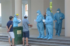 Nhân viên y tế thực hiện quy trình tiếp đón các trường hợp F1 được cách ly tại Khu ký túc xá phía Tây thành phố Đà Nẵng. (Ảnh: Văn Dũng/TTXVN) 