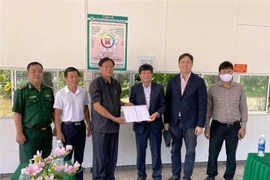 Ông Văn Công Đấu, Giám đốc Sở Ngoại vụ tỉnh Kiên Giang (thứ ba, trái) trao quà tặng của Đảng bộ, chính quyền và nhân dân tỉnh Kiên Giang hỗ trợ bà con Việt kiều nghèo. (Ảnh: Trần Long/TTXVN) 