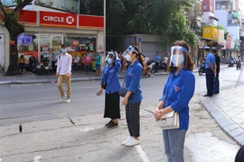 Lực lượng thanh niên tình nguyện hỗ trợ thí sinh tại điểm thi Trường Trung học Phổ thông Thăng Long. (Ảnh: Hoàng Hiếu/TTXVN) 