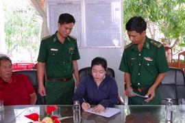 Bà Trần Hồng Diễm, chủ tàu cá CM 92114 TS, ký biên bản triển khai Quyết định của Chủ tịch Ủy ban Nhân dân tỉnh về việc xử phạt vi phạm hành chính đối với tàu vi phạm. (Ảnh: TTXVN phát)