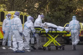 Nhân viên y tế chuyển bệnh nhân COVID-19 vào bệnh viện ở Prague, Séc. (Ảnh: AFP/TTXVN) 
