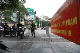 Công an phường Bách Khoa kiểm tra người tham gia giao thông tại chốt phòng, chống dịch trên tuyến phố Lê Thanh Nghị, phường Bách Khoa. (Ảnh: Vũ Sinh/TTXVN) 