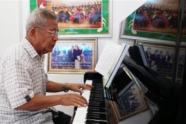 Ông Duangmixay Likaya thể hiện tác phẩm bản giao hưởng Hồng Hà-Mekong. (Ảnh: Phạm Kiên/TTXVN) 