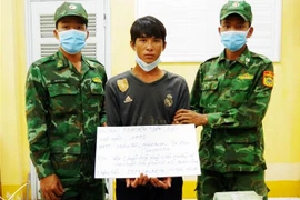 Nguyễn Văn Liệt (thứ 2 trái qua) cùng tang vật phạm tội quả tang tại Đồn Biên phòng Phú Hội, Bộ đội Biên phòng tỉnh An Giang. (Ảnh: Công Mạo/TTXVN) 