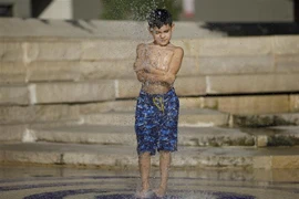 Trẻ nhỏ làm mát do nhiệt độ lên cao kỷ lục ở San Antonio, Texas, Mỹ ngày 18/7/2022. (Ảnh: THX/TTXVN) 