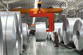 Công nhân vận hành các cuộn nhôm tại nhà máy ở Châu Bình, tỉnh Sơn Đông, Trung Quốc. (Ảnh: AFP/TTXVN)