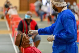 Nhân viên y tế lấy mẫu dịch xét nghiệm COVID-19 cho người dân tại Petaling Jaya, Malaysia, ngày 18/1/2021. (Nguồn: THX/TTXVN) 