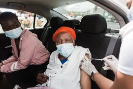 Nhân viên y tế tiêm vaccine phòng COVID-19 cho người dân tại thị trấn Bhambayi, phía Bắc Durban, Nam Phi ngày 24/9/2021. (Ảnh: AFP/TTXVN) 