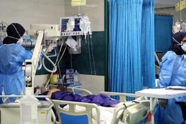 Nhân viên y tế điều trị cho bệnh nhân COVID-19 tại bệnh viện ở Iran. (Ảnh: IRNA/TTXVN) 
