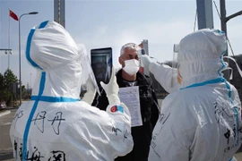 Nhân viên y tế Trung Quốc kiểm tra thân nhiệt ngăn chặn sự lây lan của dịch COVID-19 tại một trạm kiểm tra hải quan ở Suifenhe, tỉnh Hắc Long Giang, gần biên giới với Nga, ngày 1/5/2020. (Nguồn: AFP/TTXVN) 