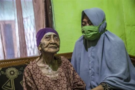Cụ bà Kamtim (trái) tại nhà riêng ở Surabaya, Đông Java ngày 31/5/2020 sau khi được xuất viện khi khỏi bệnh COVID-19. (Nguồn: AFP/TTXVN) 