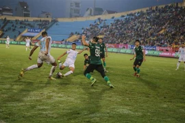 Tình huống bóng nguy hiểm trong trận đấu giữa Câu lạc bộ Thép Xanh Nam Định (áo trắng) và Câu lạc bộ Thành phố Hồ Chí Minh. (Ảnh: Công Luật/TTXVN)