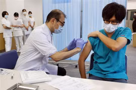 Nhân viên y tế tiêm vaccine phòng COVID-19 cho người dân tại Tokyo, Nhật Bản ngày 1/12/2021. (Ảnh: AFP/TTXVN) 