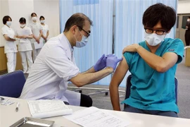 Nhân viên y tế tiêm vaccine phòng COVID-19 cho người dân tại Tokyo, Nhật Bản ngày 1/12/2021. (Ảnh: AFP/TTXVN) 