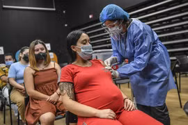 Nhân viên y tế tiêm vaccine ngừa COVID-19 của Pfizer-BioNTech cho phụ nữ mang thai tại Medellin, Colombia. (Ảnh: AFP/TXVN) 