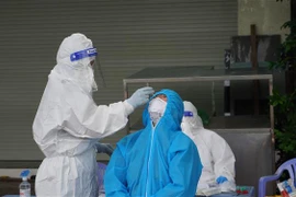 Nhân viên y tế lấy mẫu xét nghiệm cho người dân thành phố Vũng Tàu. (Ảnh: Ngọc Sơn/TTXVN) 