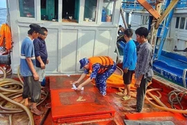 Lực lượng cảnh sát biển niêm phong số dầu không rõ nguồn gốc trên tàu cá. (Ảnh: TTXVN phát)