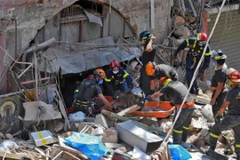 Lực lượng cứu hộ tìm kiếm nạn nhân tại hiện trường vụ nổ. (Nguồn: AFP/TTXVN) 