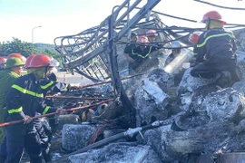 Lực lượng lấy hàng hóa ra khỏi xe và thu dọn hiện trường đảm bảo giao thông. (Ảnh: Tường Quân/TTXVN) 