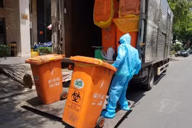 Công nhân vệ sinh thu gom, vận chuyển chất thải tại các cơ sở cách ly COVID-19. (Ảnh: Hồng Giang/TTXVN) 