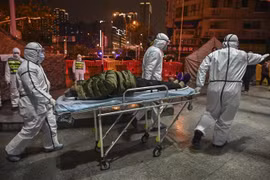Nhân viên y tế chuyển bệnh nhân nhiễm virus corona gây viêm phổi tới bệnh viện Chữ thập Đỏ ở Vũ Hán, tỉnh Hồ Bắc ngày 25/1/2020. (Nguồn: AFP/TTXVN) 
