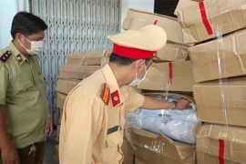 Lực lượng chức năng kiểm đếm số hàng hóa vừa bắt giữ. (Nguồn: TTXVN phát) 