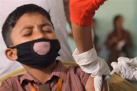 Nhân viên y tế tiêm vaccine phòng COVID-19 cho học sinh tại Agartala, bang Tripura, Ấn Độ, ngày 16/3/2022. (Ảnh: THX/ TTXVN) 