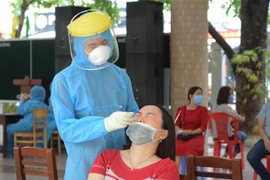 Nhân viên y tế lấy mẫu xét nghiệm cho nhân viên, cán bộ tham gia các khâu của Kỳ thi tuyển sinh lớp 10 THPT. (Ảnh: Văn Dũng/TTXVN)