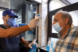 Kiểm tra thân nhiệt phòng lây nhiễm COVID-19 trước khi vào một trung tâm thương mại ở Baghdad, Iraq, ngày 13/8/2020. (Nguồn: THX/TTXVN)
