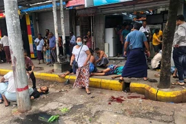 Người dân trợ giúp nạn nhân bị thương sau vụ nổ bom ở thành phố Yangon, Myanmar, ngày 31/5/2022. (Ảnh: AFP/TTXVN) 