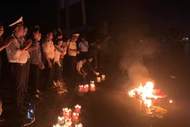 Các cựu chiến binh, thân nhân các Liệt sỹ Gạc Ma thả đèn, vòng hoa tưởng nhớ các Liệt sỹ. (Ảnh: TTXVN phát)