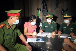 Lực lượng Đồn Biên phòng Hồ Le và Công an xã Ia Dal, huyện Ia H’Drai (Kom Tum) tuyên truyền, vận động người dân ký cam kết thực hiện các biện pháp phòng dịch COVID-19 và xuất, nhập cảnh trái phép. (Ảnh: Khoa Chương/TTXVN) 