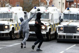 Người biểu tình ném đá vào lực lượng cảnh sát tại thành phố Belfast, Bắc Ireland, ngày 8/4/2021. (Ảnh: AFP/TTXVN) 