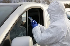 Nhân viên biên phòng Ba Lan kiểm tra thân nhiệt của một lái xe tại khu vực biên giới Ba Lan-Slovakia ngày 11/3. (Nguồn: PAP/TTXVN) 