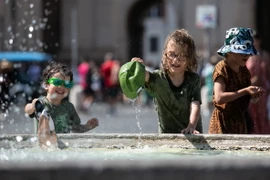 Trẻ em làm mát bên đài phun nước trong ngày nắng nóng ở Rome, Italy, ngày 14/7/2024. (Ảnh: THX/TTXVN)