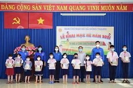 Tặng quà cho thiếu nhi có hoàn cảnh khó khăn tại xã Đông Thạnh, huyện Hóc Môn (Thành phố Hồ Chí Minh). (Ảnh: Hồng Giang/TTXVN). 