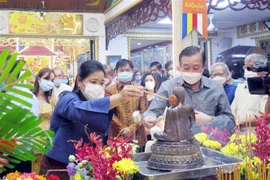 Bà Wiraka Mudhitaporn, Tổng lãnh sự Thái Lan tại Thành phố Hồ Chí Minh (trái) thực hiện nghi thức tắm Phật tại lễ hội. (Ảnh: Xuân Khu/TTXVN) 