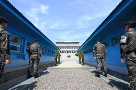 Binh sỹ Hàn Quốc (phía trước) và binh sỹ Triều Tiên (phía sau) gác tại đường giới tuyến phi quân sự giữa hai miền Triều Tiên ở Panmunjom ngày 26/4/2018. (Nguồn: AFP/TTXVN) 